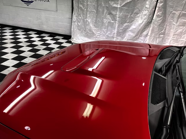Glossy red hood reflecting shop lights